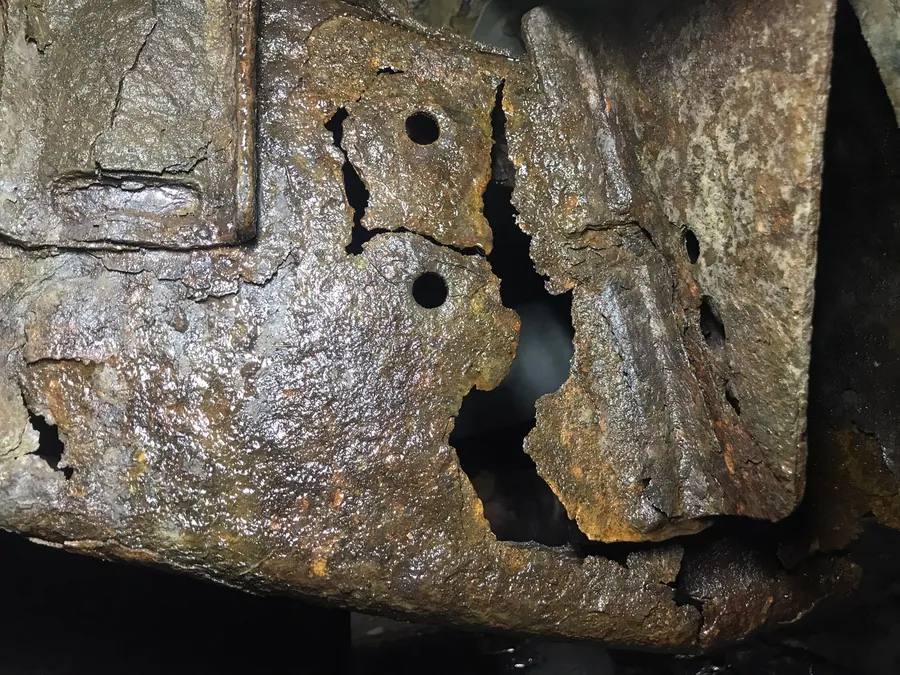 Rusted body section cut back to clean steel at a Cleveland auto body shop